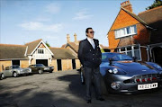 British actor Roger Moore stands beside an Aston Martin car during a 'James Bond photocall'.