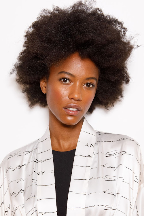 A model shows off her luscious afro backstage at the Genny fashion show.