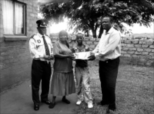 SURVIVOR: Lucaster Mongwe is flanked by his mother, Christina, Captain Sebotsaro Motadi and Jerry Mabusela who donated school uniforms to the pupil. 24/02/09. Pic. Alex Matlala. © Sowetan.