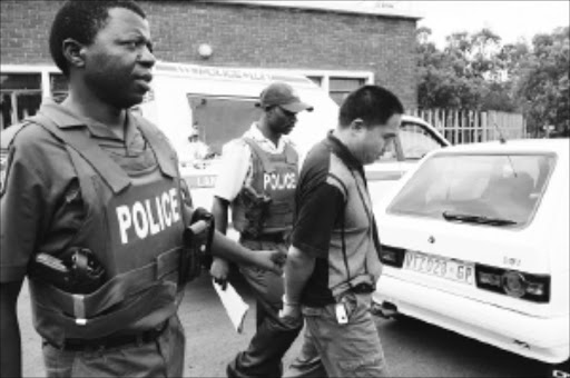 NABBED: A Chinese man is arrested at Langlaagte testing station for allegedly possessing a fraudulent document. Pic: Mohau Mofokeng. 04/01/2010. © Sowetan.