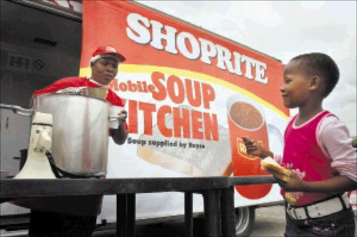 FEEDING THE HUNGRY: Sarah Maboena, Shoprite soup assistant, serving warm soup to children at the Skeen Primary School in Alexandra. © Unknown