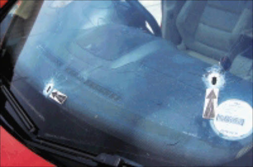 LUCKY ESCAPE: Two of the bullet holes in Vedzisane Tshukudu's Golf 5. Others are in the front left passenger door, the left front wheel and the driver's seat. Pic: Peggy Nkomo. 28/10/2009. © Sowetan.