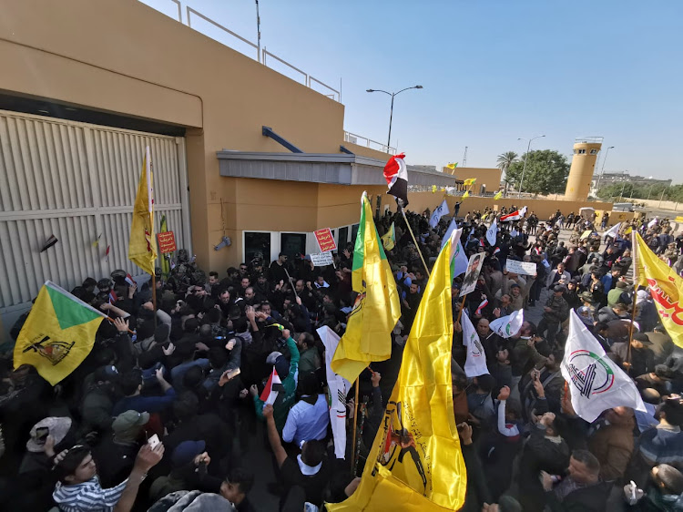 Protesters and militia gather to condemn air strikes on bases belonging to Hashd al-Shaabi, outside the main gate of the US embassy in Baghdad, Iraq, on December 31 2019.