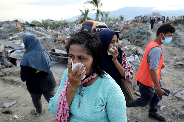 Women react while visiting Petobo neighbourhood which was hit by an earthquake and liquefaction in Palu, Central Sulawesi, Indonesia, October 8, 2018.