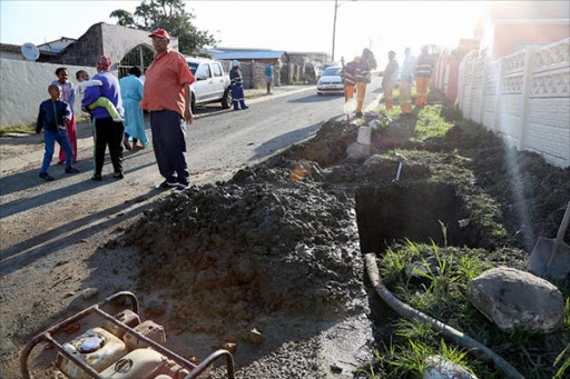 DESPERATE: Buffalo Flats resident Errol de Klerk, foreground, with members of the community outside his house where a burst pipe has left some houses without water Picture: MARK ANDREWS