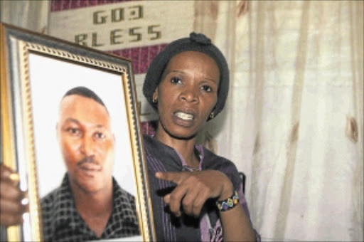 UNENDING GRIEF: Mbali Mokubung, 34, holds a picture of the slain lover, Sipho Mokoena, who she cannot bury because he was an illegal immigrant. Photo: Tshepo Kekana