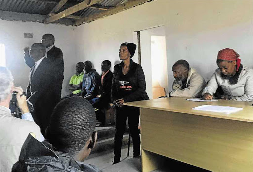 TAKING FLAK: Sanral CEO Skhumbuzo Macozoma faces the heat in a packed Umgungundlovu tribal authority hall in Xolobeni. He is standing in front, slightly obscured Picture: SUPPLIED