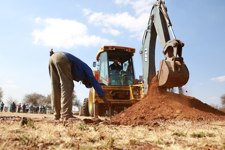Grave diggers seen working during on an on-site visit by Dr Bandile Masuku, MEC of health in Gauteng.