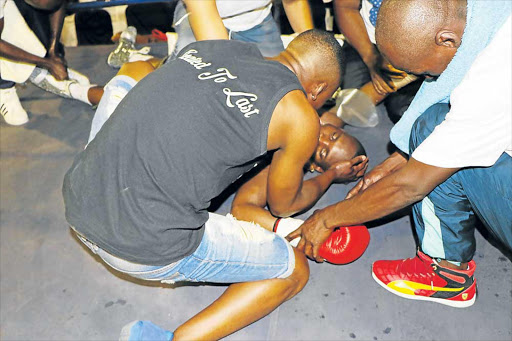 FLASHBACK: Zolani Tete helps his brother Makazole after he was knocked unconcious by Jonas Sultan in their IBF junior bantam intercontinental fight at the Mdantsane Indoor Sport Centre on December 16 Picture: MICHAEL PINYANA