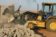 A catapillar at work during a structural demolition by the Department of Housing. File picture.