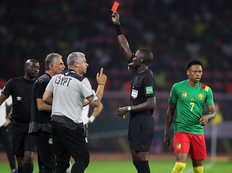 Egypt coach Carlos Queiroz, left and obscured,) receives a red card from peferee Bakary Papa Gassama in the 2021 Africa Cup of Nations semifinal against Cameroon at Olembe Stadium in Yaounde on February 3 2022.