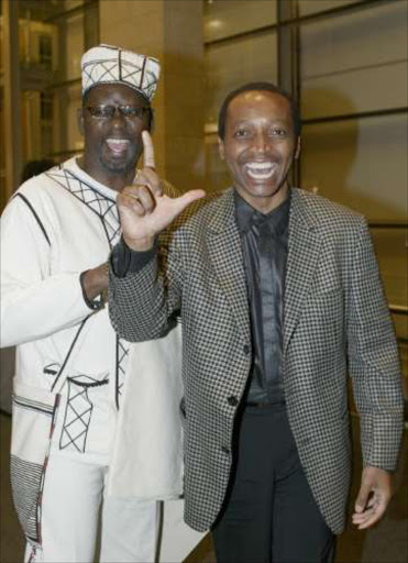 L IS FOR . . . LEAVING YOUR COMFORT ZONE: Zwelinzima Vavi and Patrice Motsepe clown around at the Cape Town Fashion Festival. Pic: Ambrose Peters. 14/04/05. © SUNDAY TIMES.
