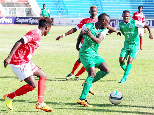 Gor Mahia’s Geoffrey Walusimbi shields the ball from Western Stima’s Dennis Sikhayi during their SPL match at Nyayo Stadium yesterday. /ENOS TECHE
