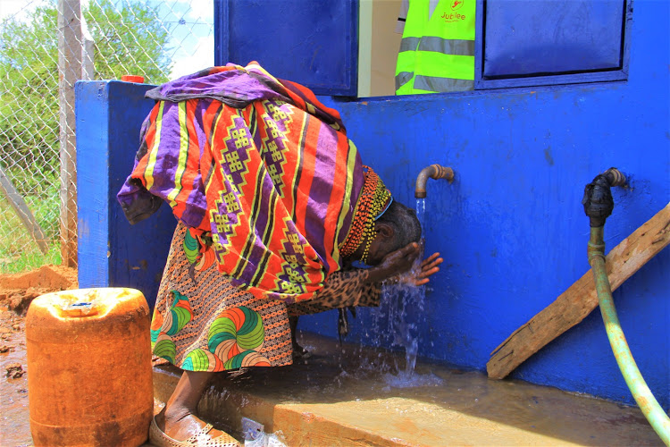 A woman cools off her head after fetching water at the borehole built by the county government of Isiolo/