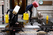 Activists from the climate action group Ocean Rebellion perform a stunt outside The Baltic Exchange building, in London, Britain November 16, 2020. 