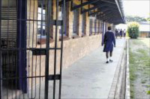 'SERIOUS ALLEGATIONS':A pupil walks towards a group of fellow pupils at Makhumbuza High School in Umlazi where five 'predator' teachers were suspended. 04/05/09. Pic. Thuli Dlamini. © Sowetan.