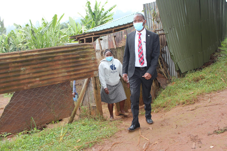 Murang'a health executive Joseph Mbai leaving the home of a teen mother in Kangema, Murang'a.With him is Caroline Macharia, county head of reproductive health murang'a level 5 Hospital.