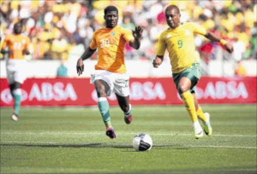 EYES ON THE BALL: Bafana Bafana striker Katlego Mphela wins the ball against Ivory Coast's Igor Lolo during the 2011 Nelson Mandela Challenge at the Nelson Mandela Bay Stadium in Port Elizabeth. Photo: THEMBINKOSI DWAYISA