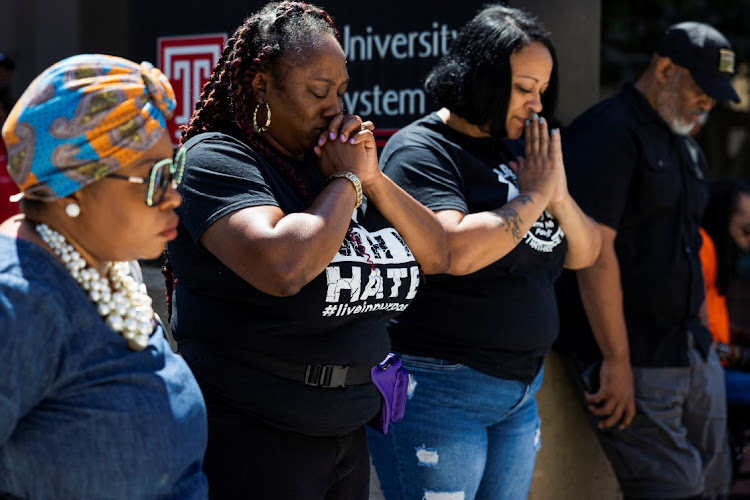 Dr. Deshawnda Williams (2L) prays alongside community members at an anti-gun violence rally held in Philadelphia, Pennsylvania, U.S., June 4, 2022.