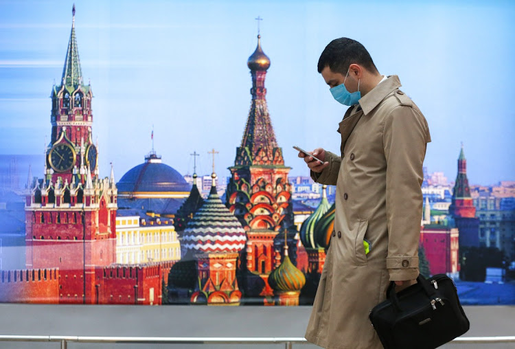 A passenger checks his mobile phone in the departures terminal at Sheremetyevo International Airport OAO in Moscow, Russia, on Friday, Oct. 9, 2020. Russia posted a record number of new Covid-19 cases Friday as the government has resisted returning to a lockdown to battle the second wave of infections.