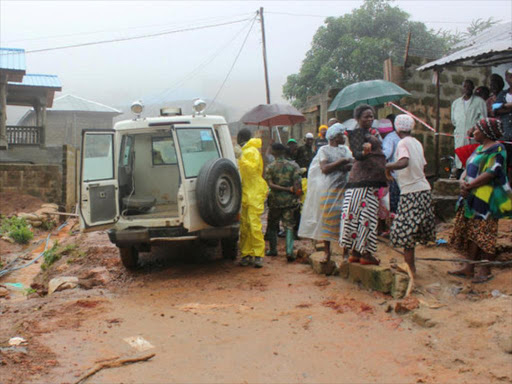 A file photo of residents standing near an ambulance after a mudslide in the mountain town of Regent, Sierra Leone August 14, 2017. /REUTERS