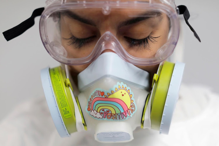 Alisha Narvaez poses for a photo in her personal protective equipment, before embalming a deceased person. Picture: REUTERS/ANDREW KELLY