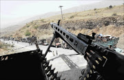 WAR
      
       MACHINE: A Pakistani soldier keeps vigil while a line of vehicles are pictured as Pakistani civilians, fleeing a military operation in North Waziristan, wait to cross a checkpoint at the Bannu Frontier Region registration centre for internally displaced people in Saidgai yesterday
      
      . Pakistani helicopter gunships pounded militant targets in the country's northwest on June 21, killing up to 30 rebels, as the number of civilians fleeing a long-awaited offensive there surpassed 300000
      PHOTO: A MAJEED/AFP