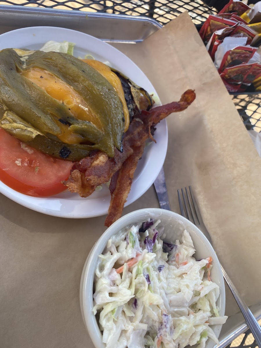 Bacon cheeseburger on a bit of lettuce with a green chile