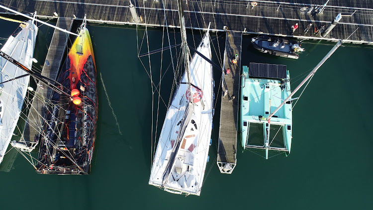 The catamaran uses a combination of sails, hydro-electric power and solar energy. Here it sits in the marina with the yacht (left) that Norbert Sedlacek Koch intends to sail single-handedly around the world later this year.