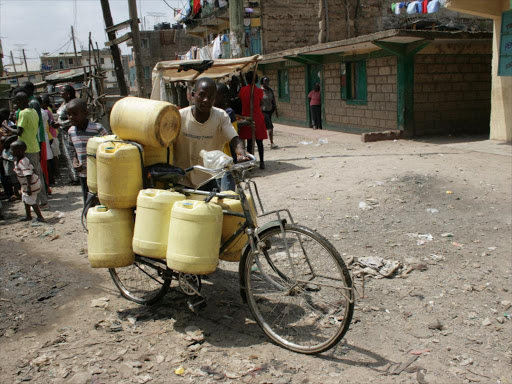 SHORTAGE A man pushes water on the bicycle in Kayole estate, Nairobi. The tunnel is expected to solve the city’s water problems