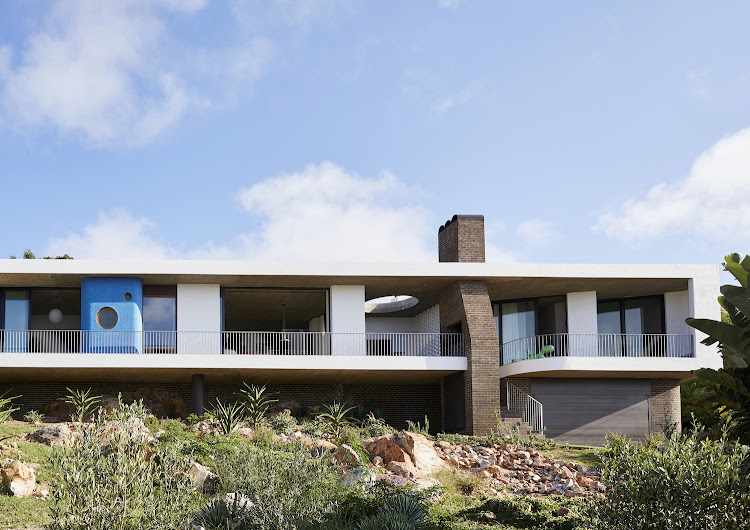 Carefully positioned along the site’s rocky contours, the house has a strongly linear design punctuated by the strong vertical element formed by the braai chimney.