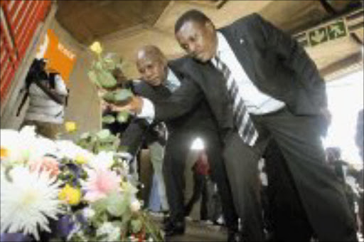 SOLEMN: Kaizer Chiefs and Orlando Pirates bosses Kaizer Motaung and Irvin Khoza lay wreaths at the last disaster memorial service at Ellis Park Stadium yesterday. Pic. Antonio Muchave. 11/04/07. © Sowetan.