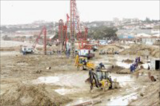 GRINDING: Graders clear the ground as builders work on the Nelson Mandela Bay Stadium in Port Elizabeth. Pic. Antonio Muchave. © Sowetan.