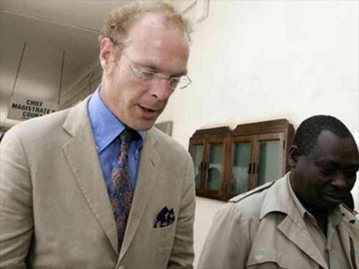 The late Thomas Cholmondeley (L), the son of the 5th Lord Delamere and one of Kenya's largest landowners, being escorted out of the High Court by police after a hearing of his murder trial, February 6, 2007. /REUTERS