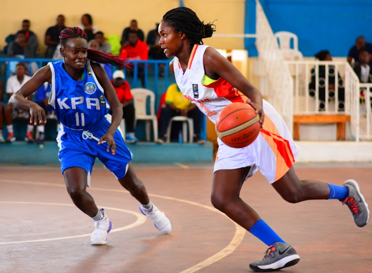 Equity Bank's Betty Kananu (R) charges past Debra Atieno of KPA during a past KBF match