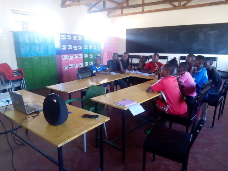 Girls improvising by using one laptop due to a power cut during a learning session