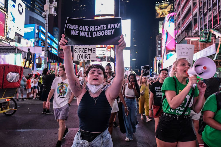 Abortion rights demonstrators hold signs while walking through Times Square during a protest in New York, US, on Friday, June 24, 2022. A deeply divided US Supreme Court overturned the 1973 Roe v. Wade decision and wiped out the constitutional right to abortion, issuing a historic ruling likely to render the procedure largely illegal in half the country.