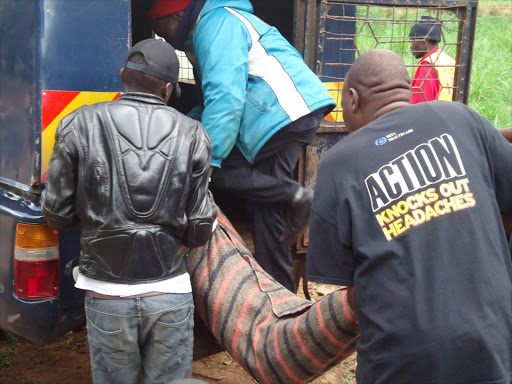 A file photo of police and members of the public taking the body of a teen who committed suicide to a mortuary.