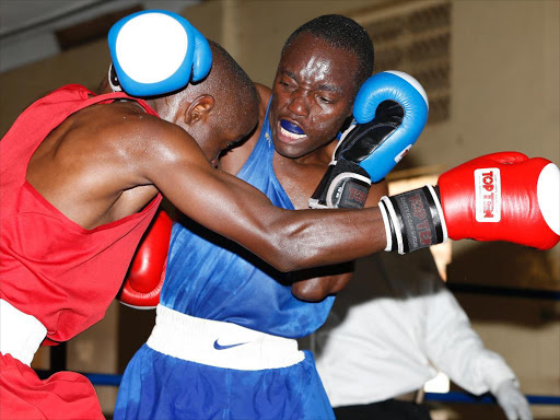 Matayo Keya (L) of KNH trade punches with Peter Mungai of Kenya Police in their 49kg lightweight bout at Kaloleni Social hall in Nairobi on July 03, 2015 during the All Africa Games team trials./FILE