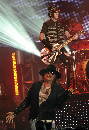 Axl Rose performs during a Guns N’ Roses concert at Fillmore in Silver Spring, Maryland, in 2012. The lead guitarist is DJ Ashba, who played with the band from 2009 to 2015.
