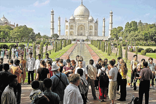 MANY A KODAK MOMENT: Above, tourists marvel at the historic Taj Mahal in Agra in northern India. Below, a boy and girl enjoy being Mowgli in 'The Jungle Book' for a day