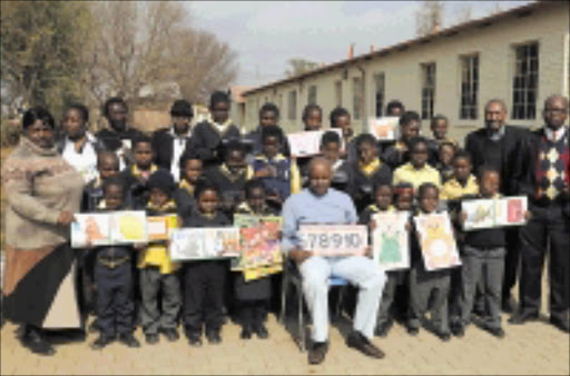 COMPASSIONATE: Patrick Moore, standing third from left (back row) donated school uniforms to 15 orphans at his former school, Enkolweni Primary. Pic. Peter Mogaki. 18/07/08. © Sowetan.