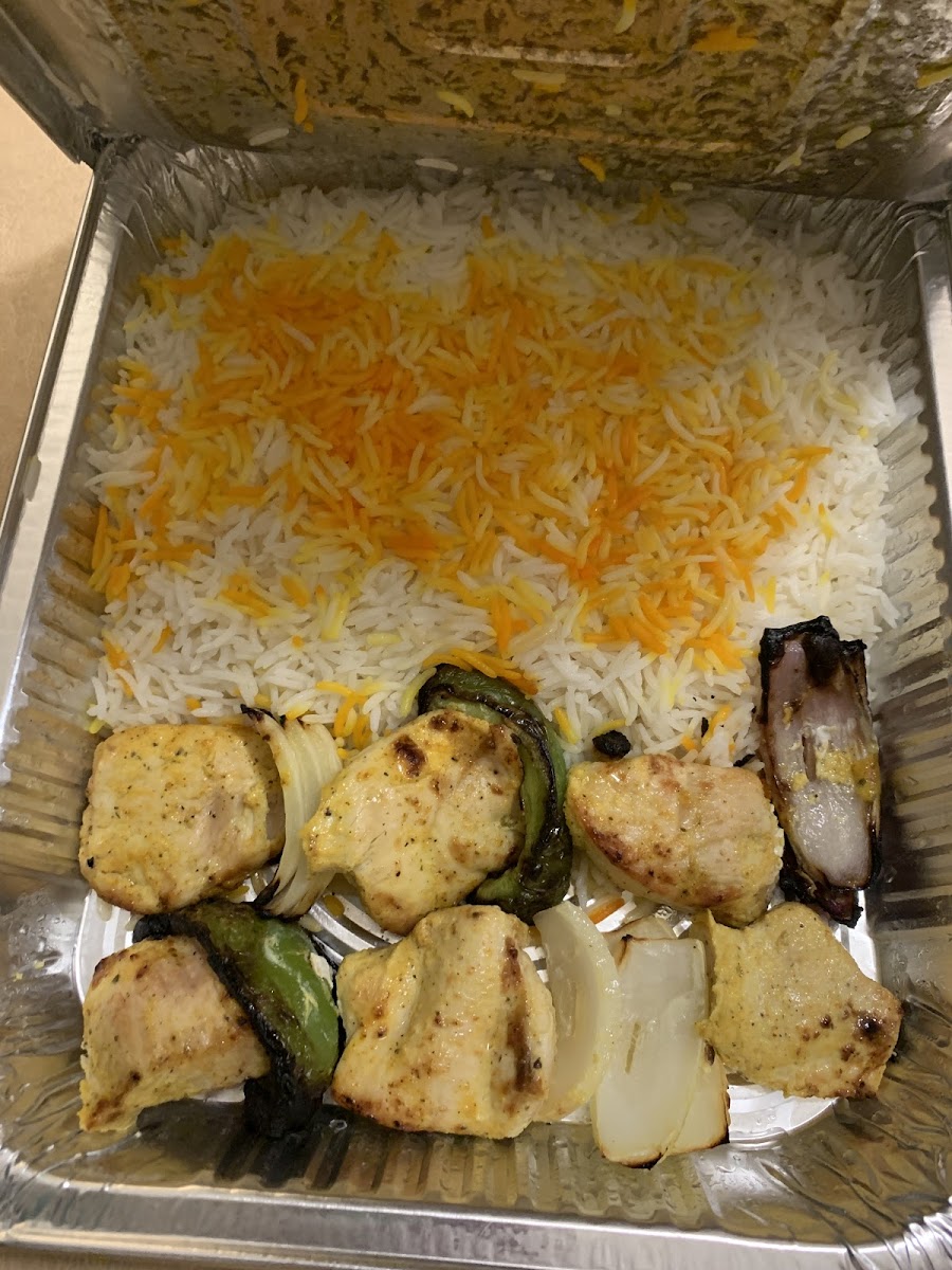 Chicken kabob with rice. Tomato in separate container