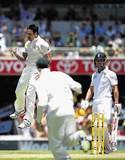 FEAR FACTOR: Mitchell Johnson of Australia takes the wicket of Jonathan Trott of England during day two of the first Ashes Test at The Gabba in Brisbane, Australia