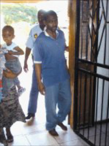 IRON CLAD: Mhala police escort Doctor Makaringe into the Thulamahashe health centre. Pic. Riot Hlatshwayo. 30/01/2007. © Sowetan.