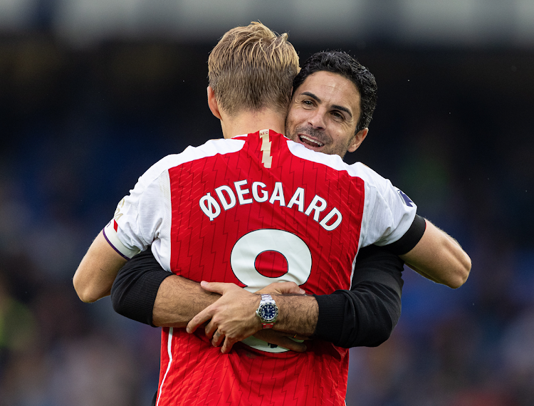 Arsenal's head coach Mikel Arteta (R) celebrates with captain Martin odegaard after a recent English Premier League match against Everton