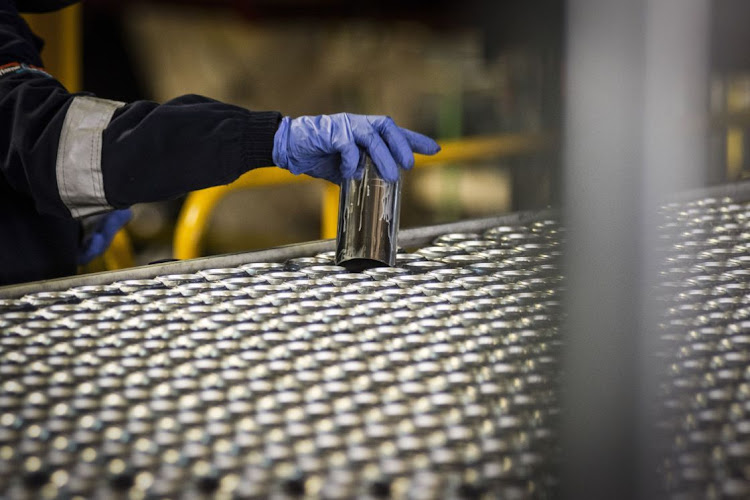 A worker lifts an aluminium can from the production line at the Nampak's Springs manufacturing plant. Picture: WALDO SWIEGERS/BLOOMBERG