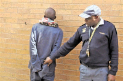 IN CUFFS: Inspector Moses Maphakela believes they have caught the man who has been terrorising Joburg motorists for more than a year. 20/05/09. Pic. Peter Mogaki. © Sowetan.