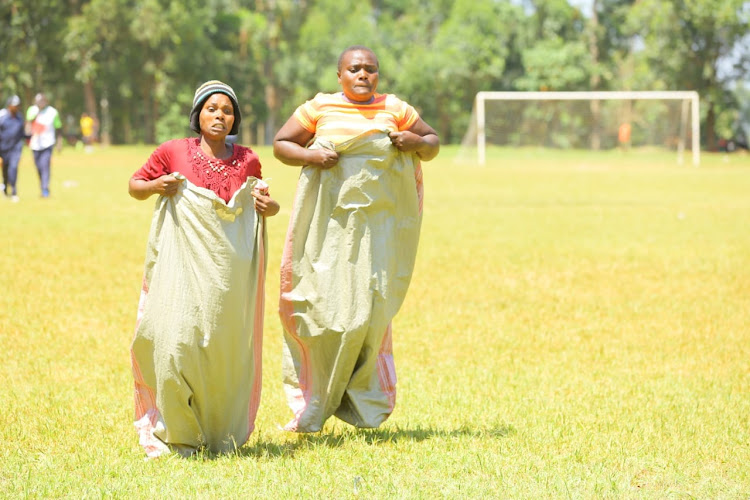 Women participate in the sack race during the sports bonanza
