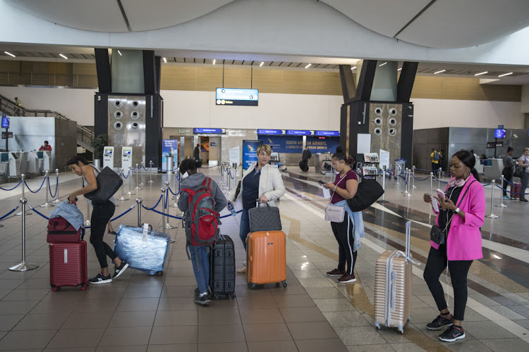 Passengers queue at the check-in desks inside the departures hall at O.R. Tambo International Airport. SA is to send a plane to Wuhan, China, within days to bring back an estimated 134 citizens from the city where the virus was first detected.